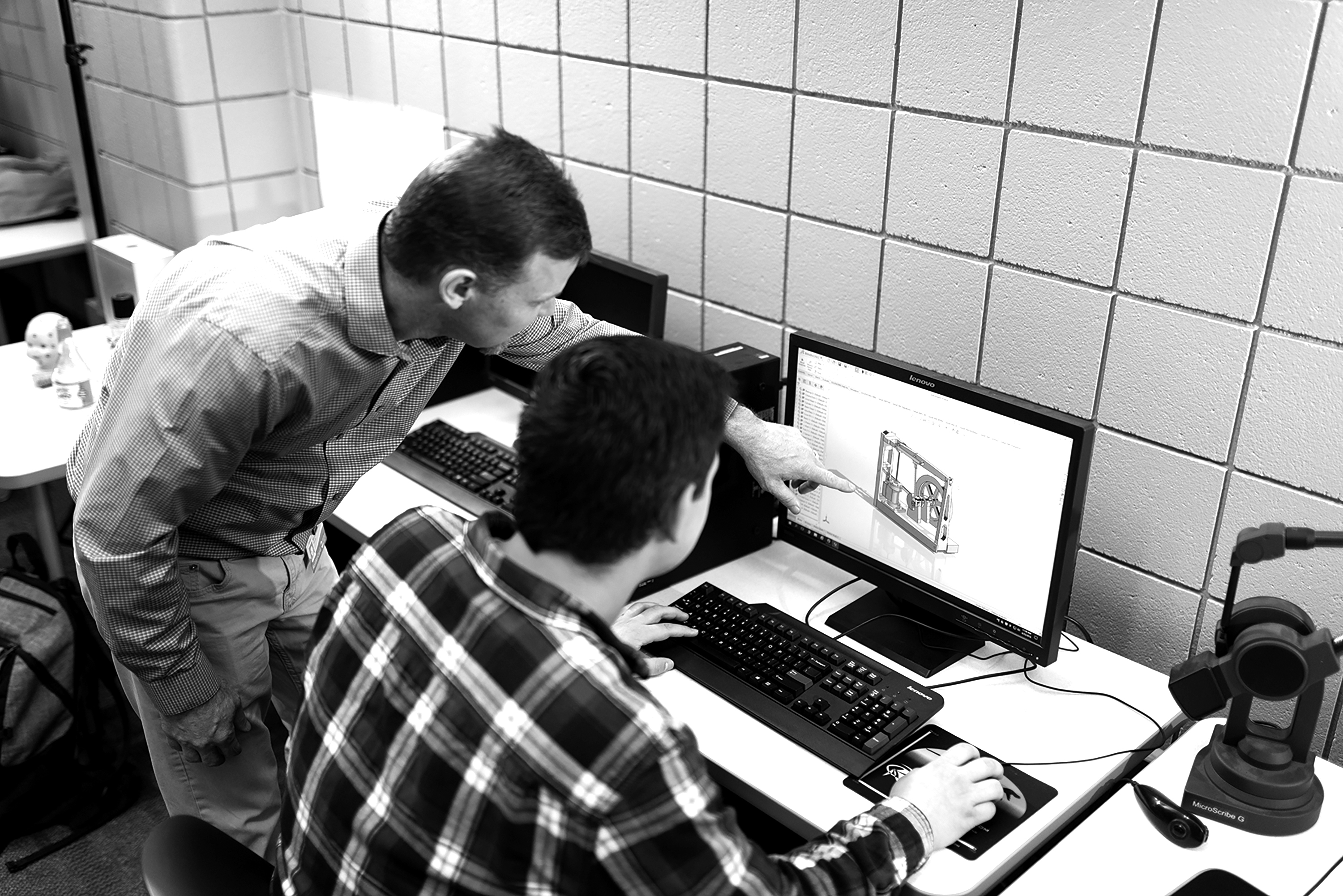 GRCC Professor assisting a student with a CAD drawing on the computer