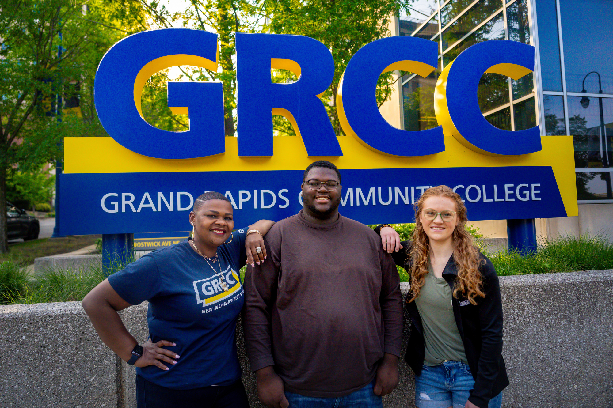 Three GRCC Students in front of GRCC Sign by Science Building